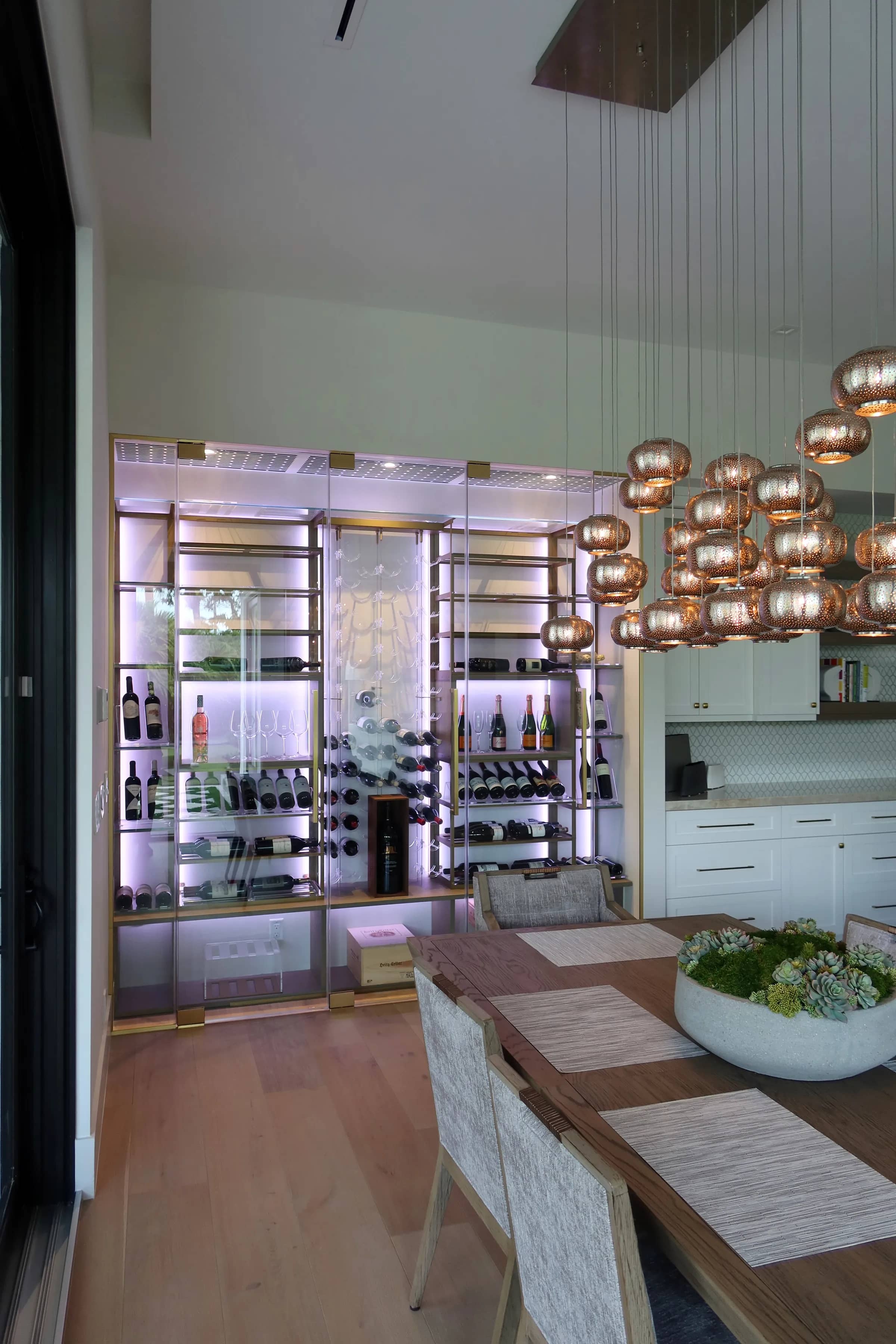 Custom wine wall Miami featuring glass enclosure, illuminated bottle displays, and contemporary luxury wine storage — photograph 1 of 3