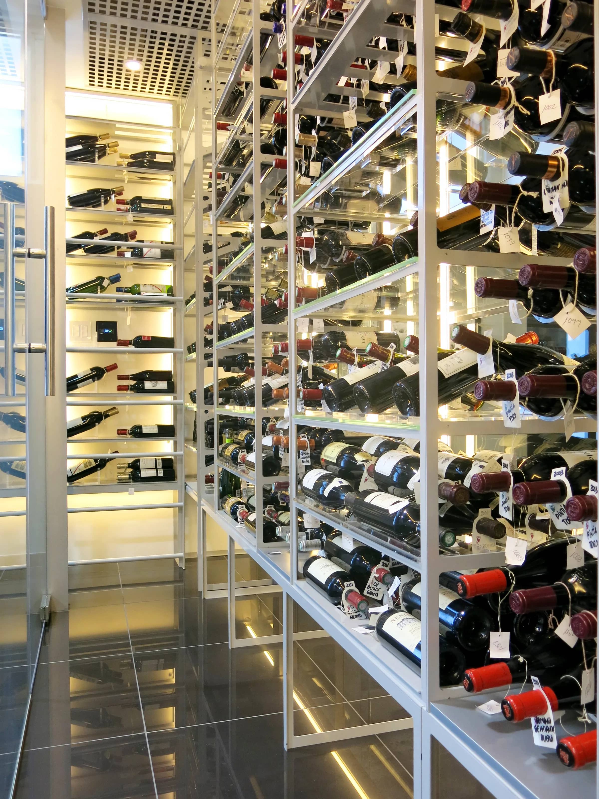 Custom understairs wine cellar miami featuring glass enclosure, metal and illuminated wine racks , modern design — photograph 2 of 4