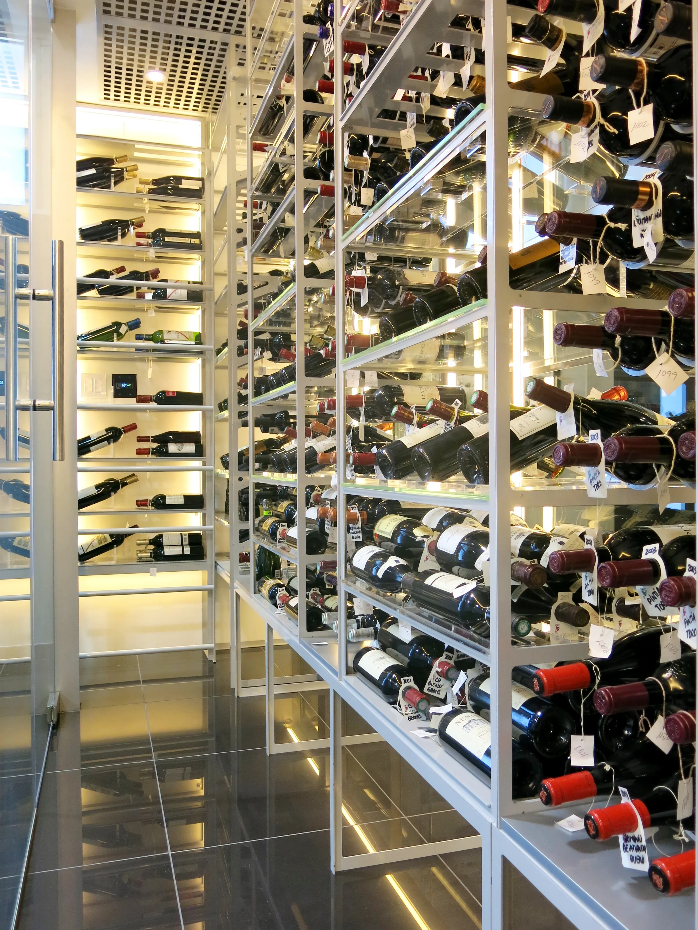 Custom understairs wine cellar miami featuring glass enclosure, metal and illuminated wine racks , modern design — photograph 2 of 4