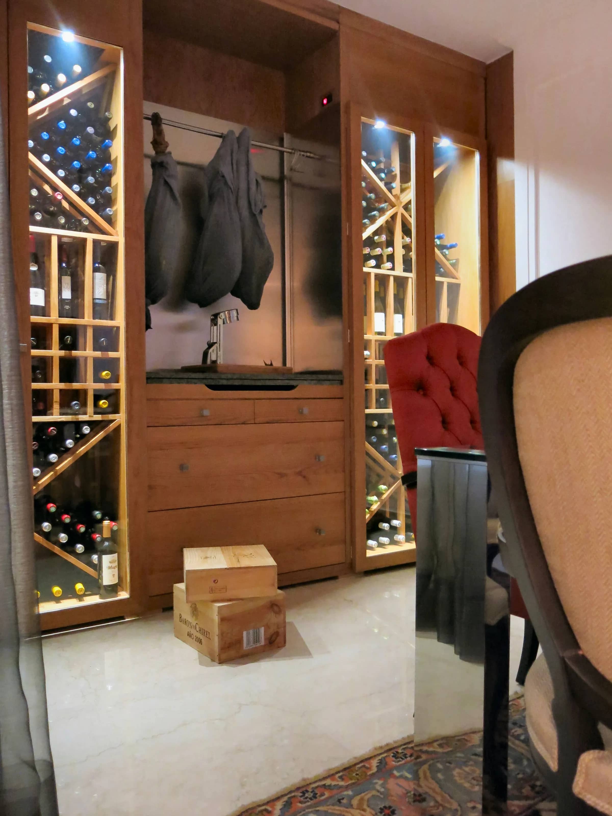 Custom commercial wine cellar wall mounted wine racks and glass wine room panels at Vinoteca Velazquez