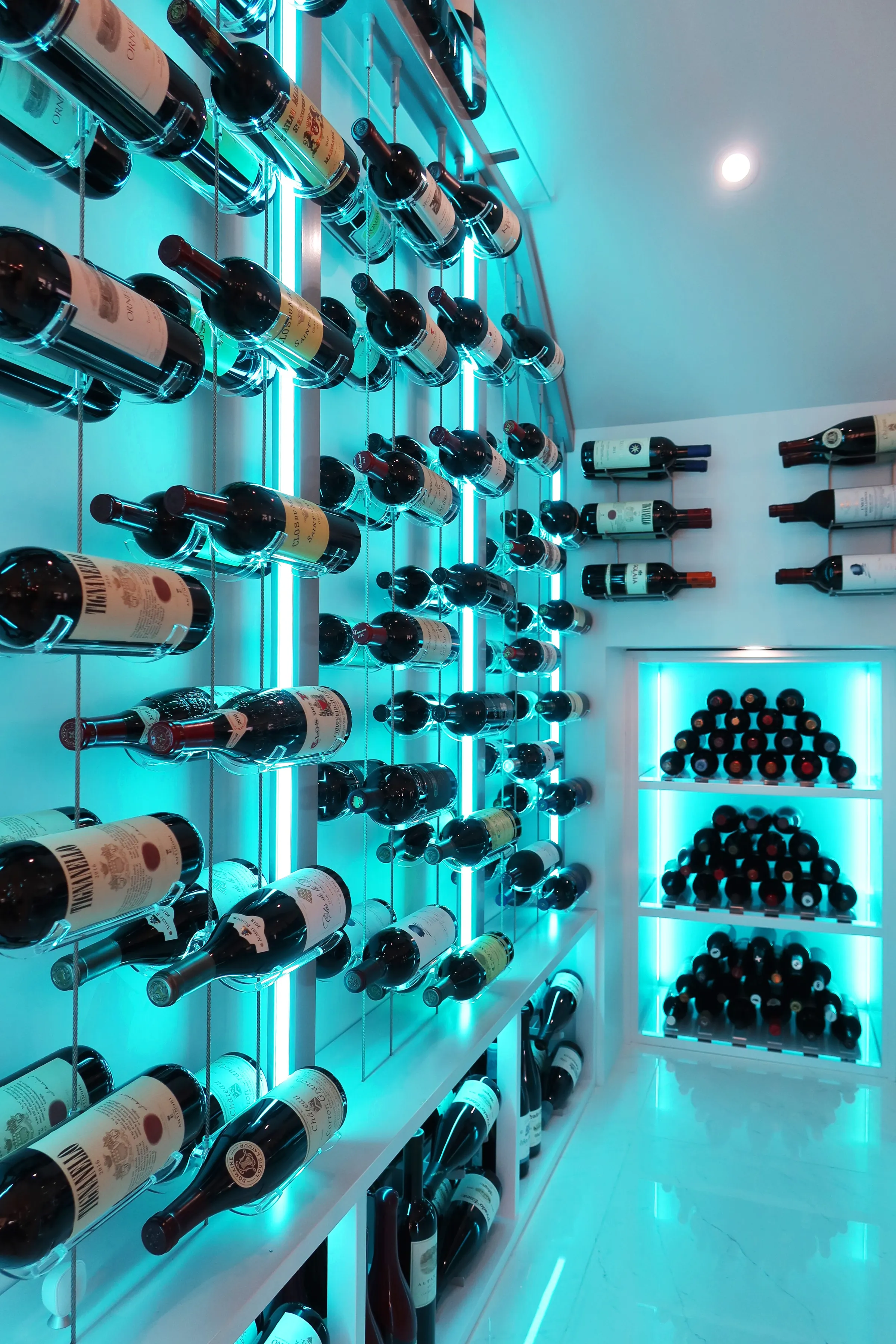 Custom understairs wine cellar Miami featuring glass enclosure, illuminated wine racks, and luxury wine storage design — photograph 1 of 3