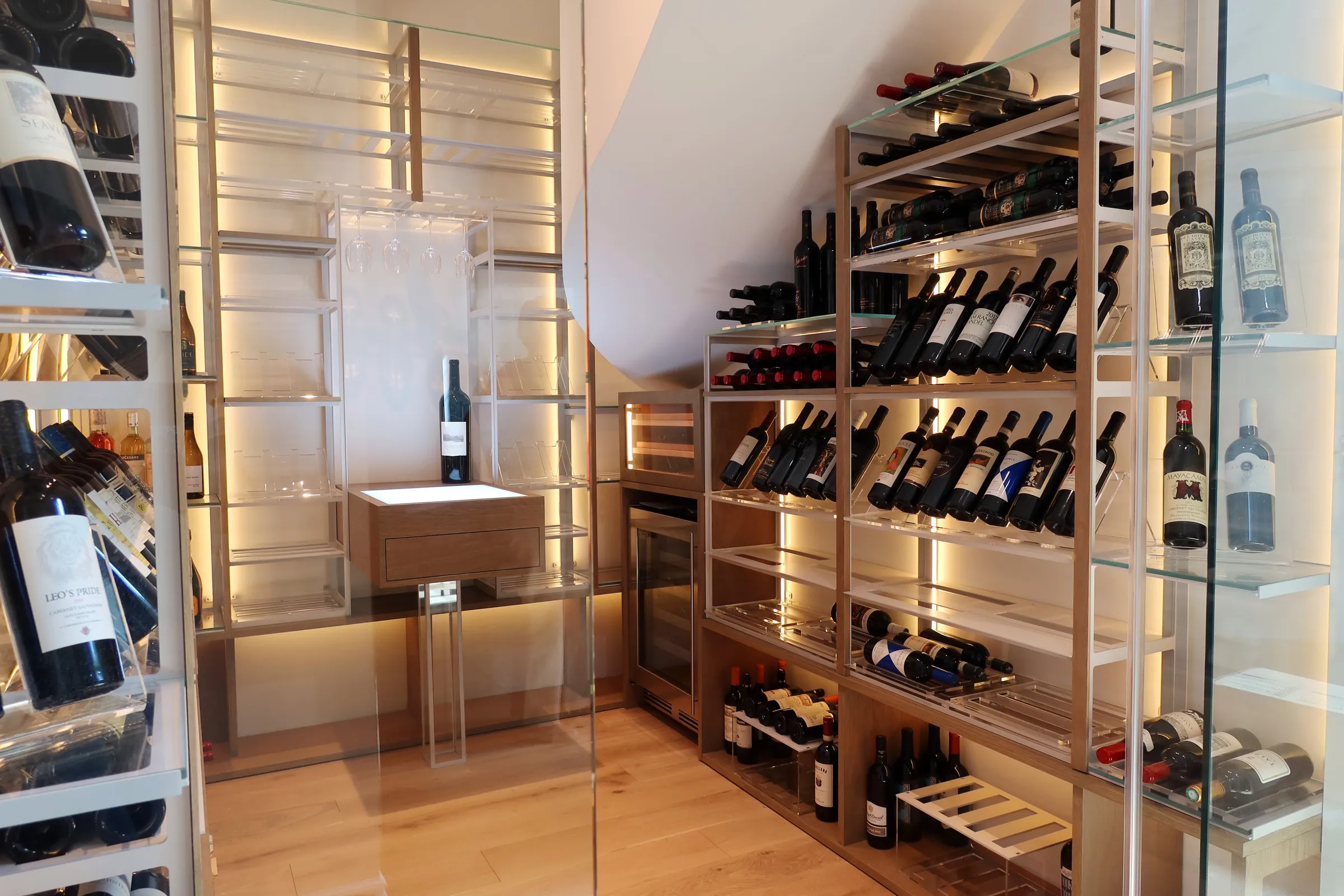 Custom understairs wine cellar miami featuring glass enclosure, metal and wooden illuminated wine racks design — photograph 2 of 4