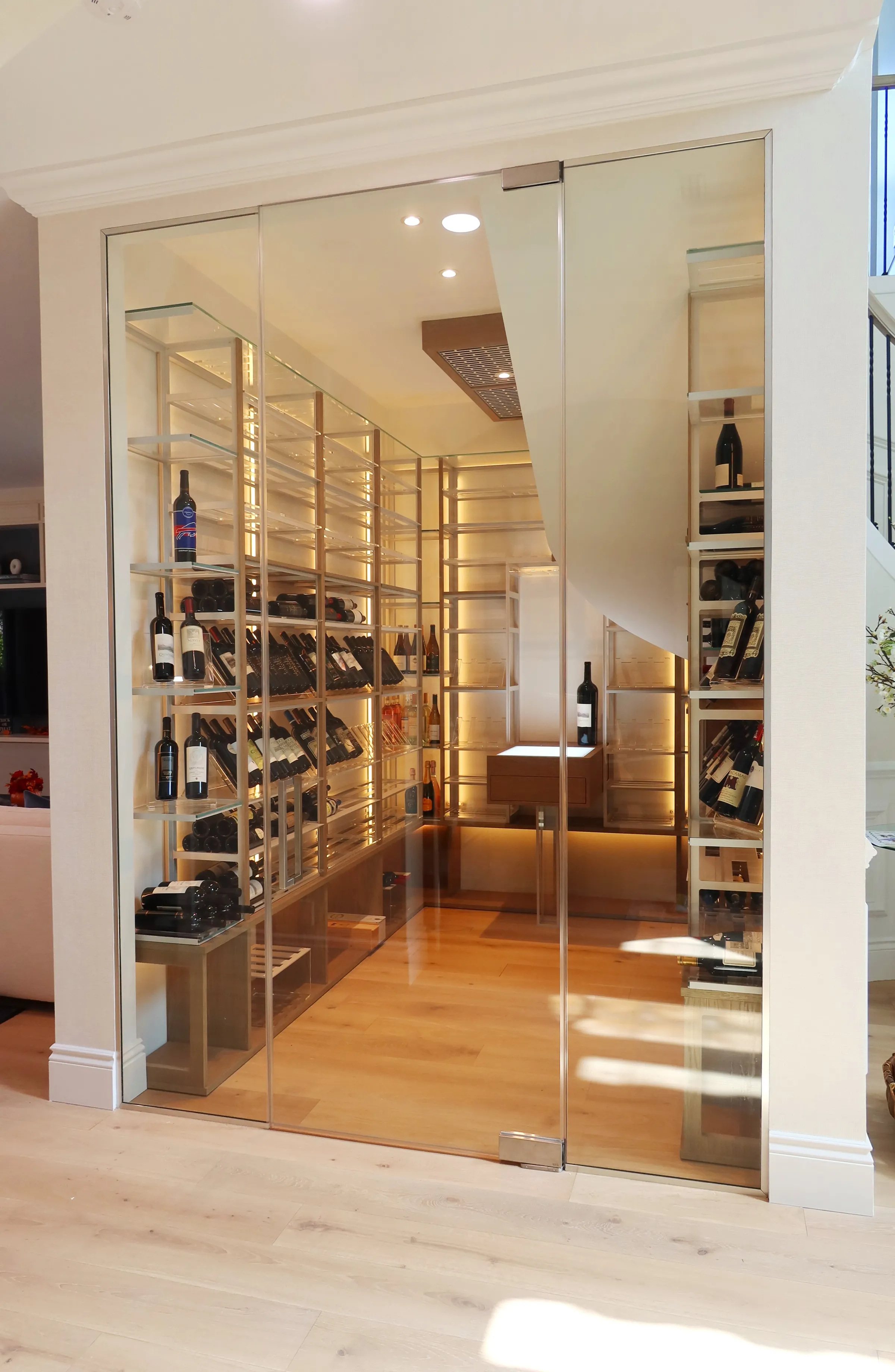 Custom understairs wine cellar miami featuring glass enclosure, metal and wooden illuminated wine racks design — photograph 3 of 4