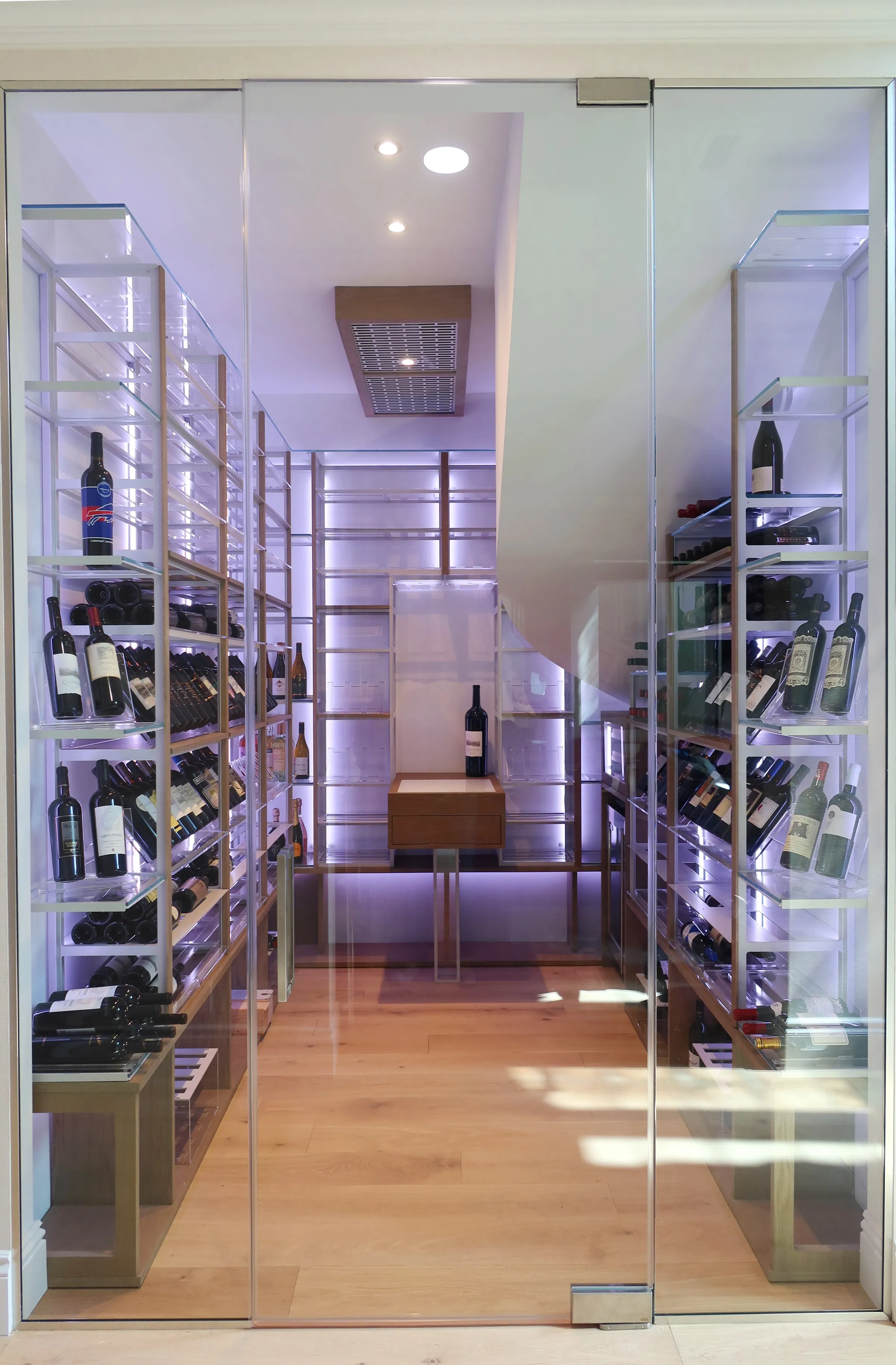 Custom understairs wine cellar miami featuring glass enclosure, metal and wooden illuminated wine racks design — photograph 4 of 4