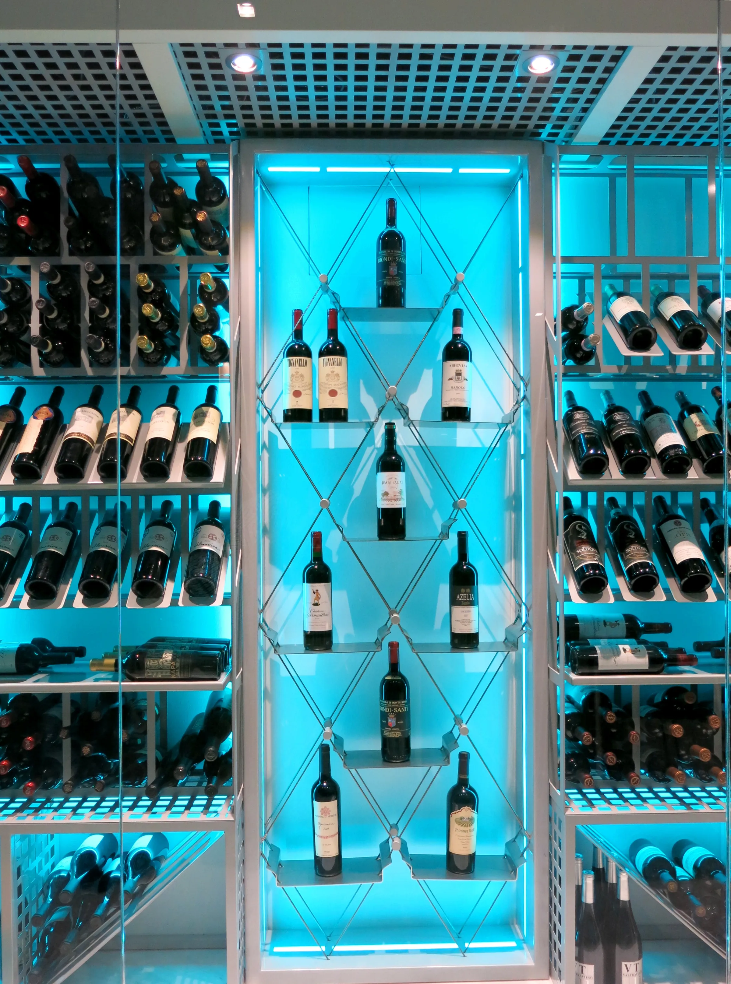 Custom wine cellar Miami featuring glass enclosure, illuminated bottle displays, and modern luxury wine storage — photograph 1 of 3
