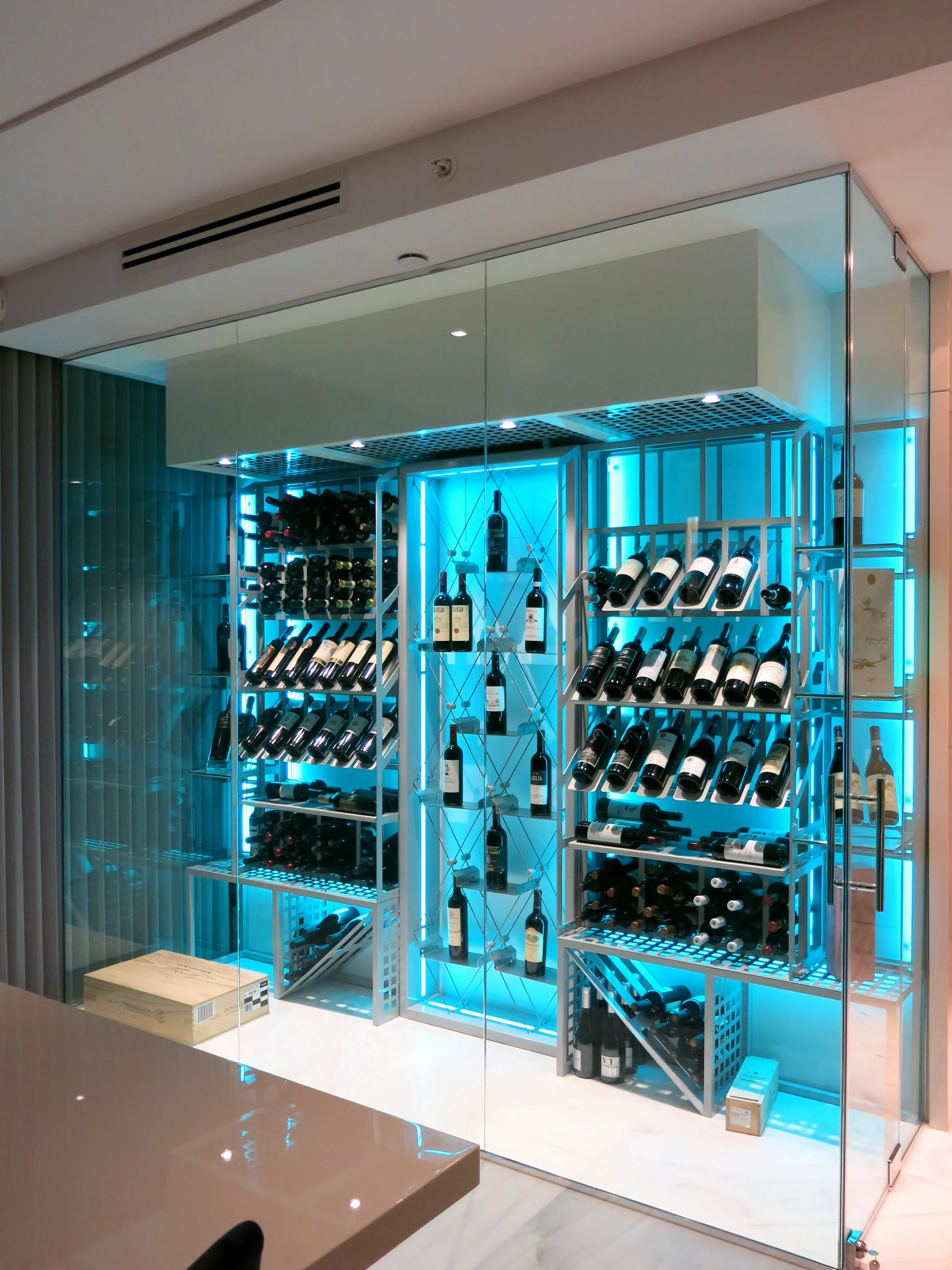 Custom wine cellar Miami featuring glass enclosure, illuminated bottle displays, and modern luxury wine storage — photograph 2 of 3