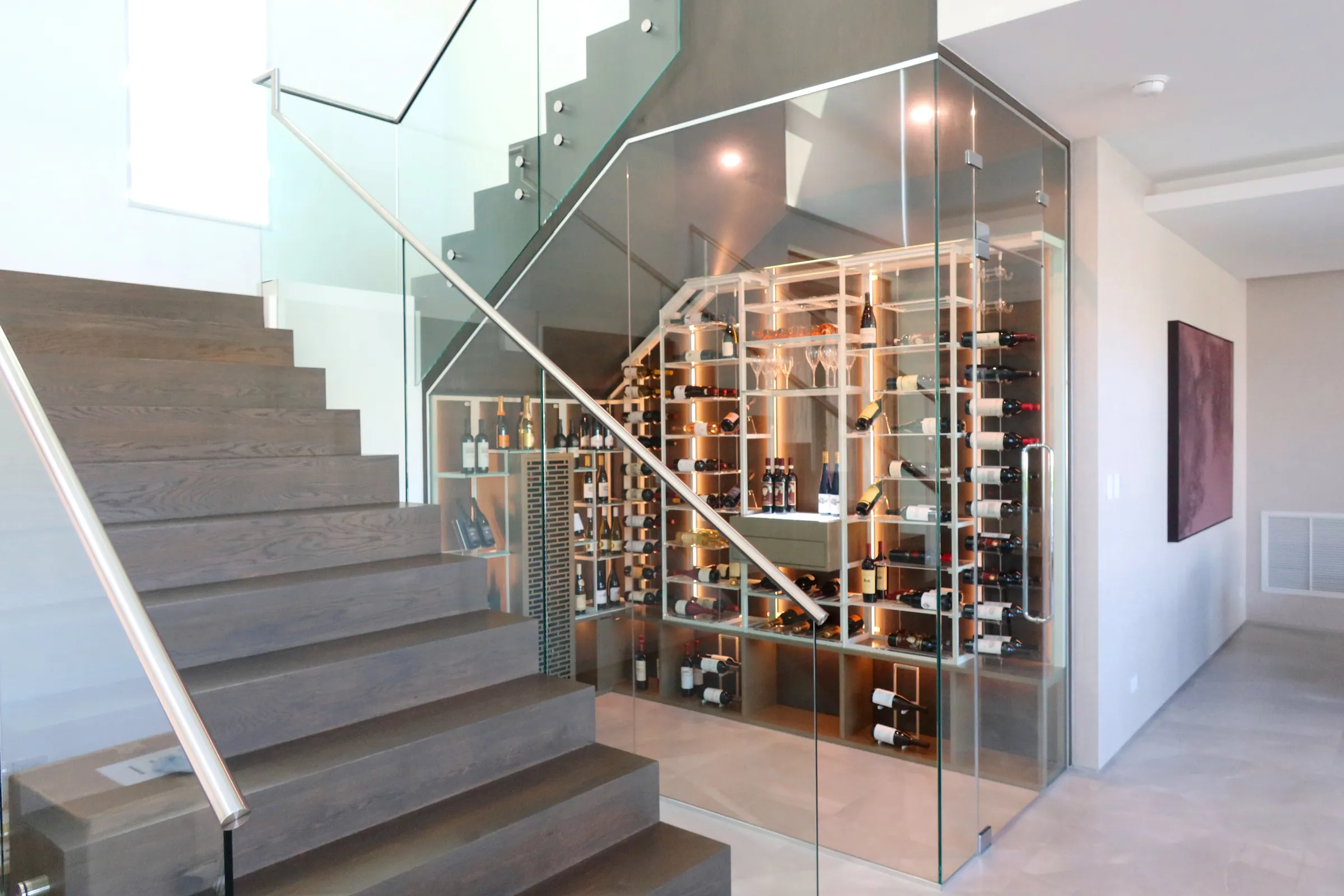 understairs wine room in south Florida, glass enclosures, wall-mounted metal wine racks, contemporary wine cellar design, luxury wine storage — photograph 3 of 4
