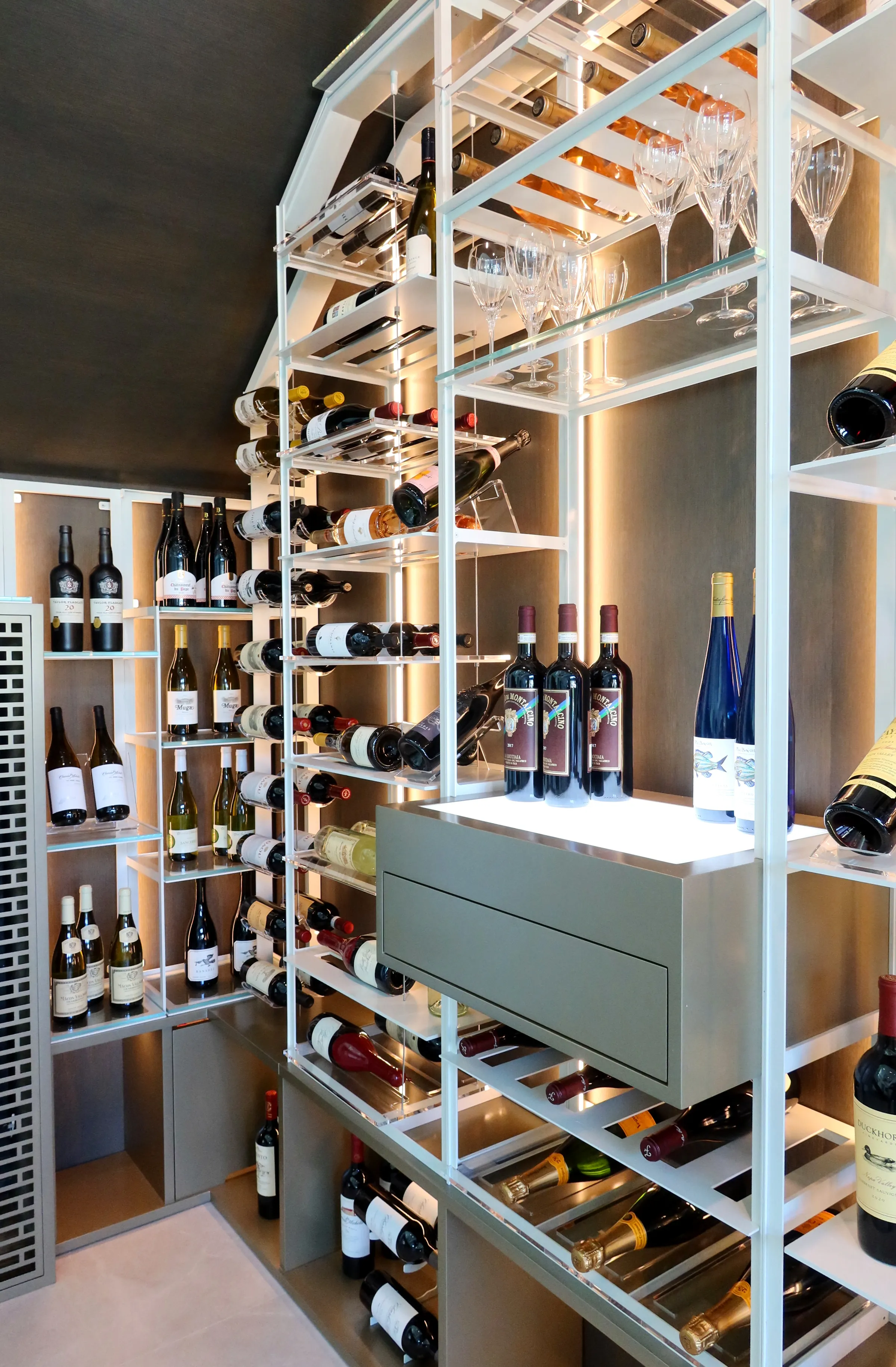 understairs wine room in south Florida, glass enclosures, wall-mounted metal wine racks, contemporary wine cellar design, luxury wine storage — photograph 4 of 4