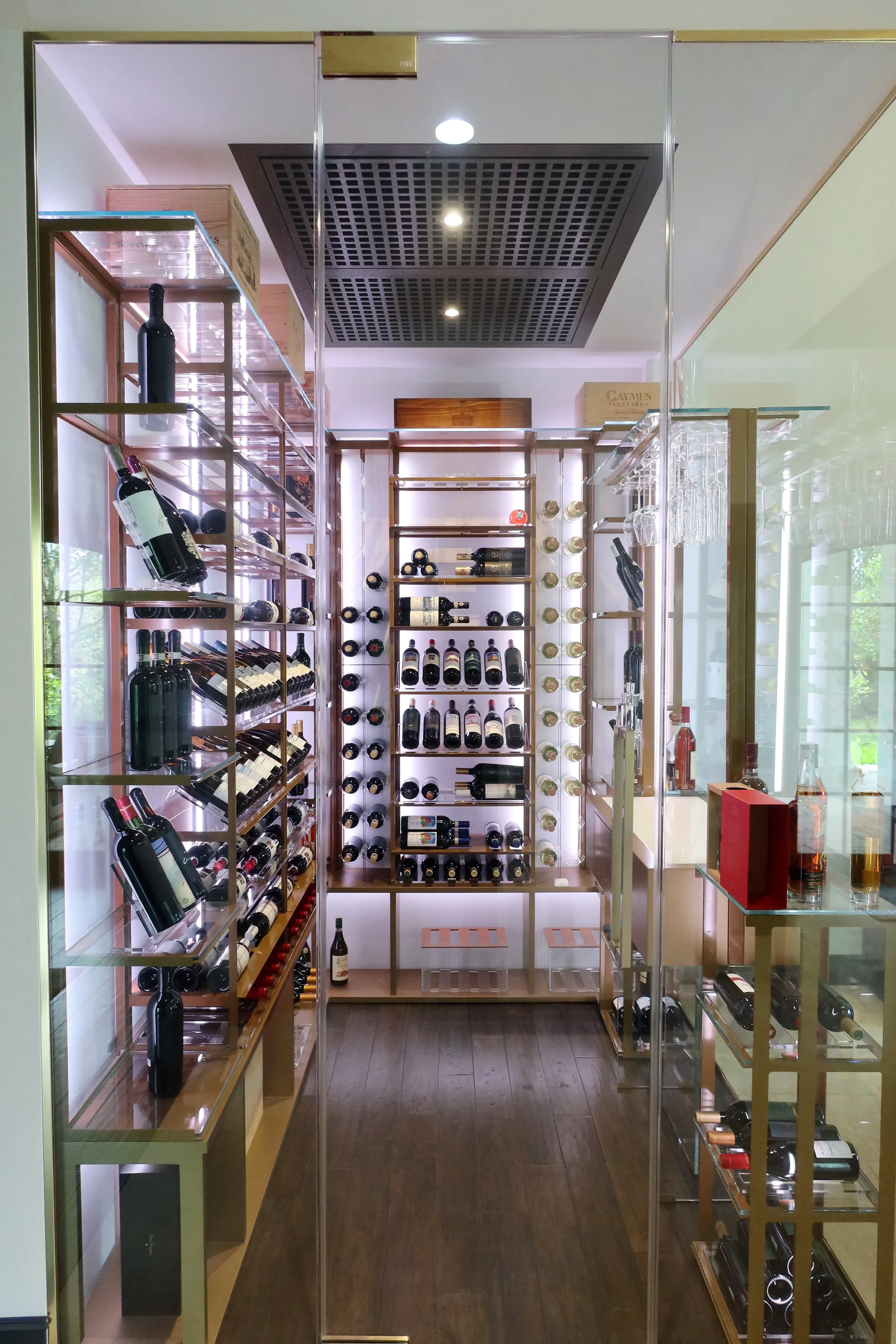 Luxury glass wine cellar Miami featuring custom metal wine racks, LED lighting, and floor-to-ceiling wine storage — photograph 4 of 6