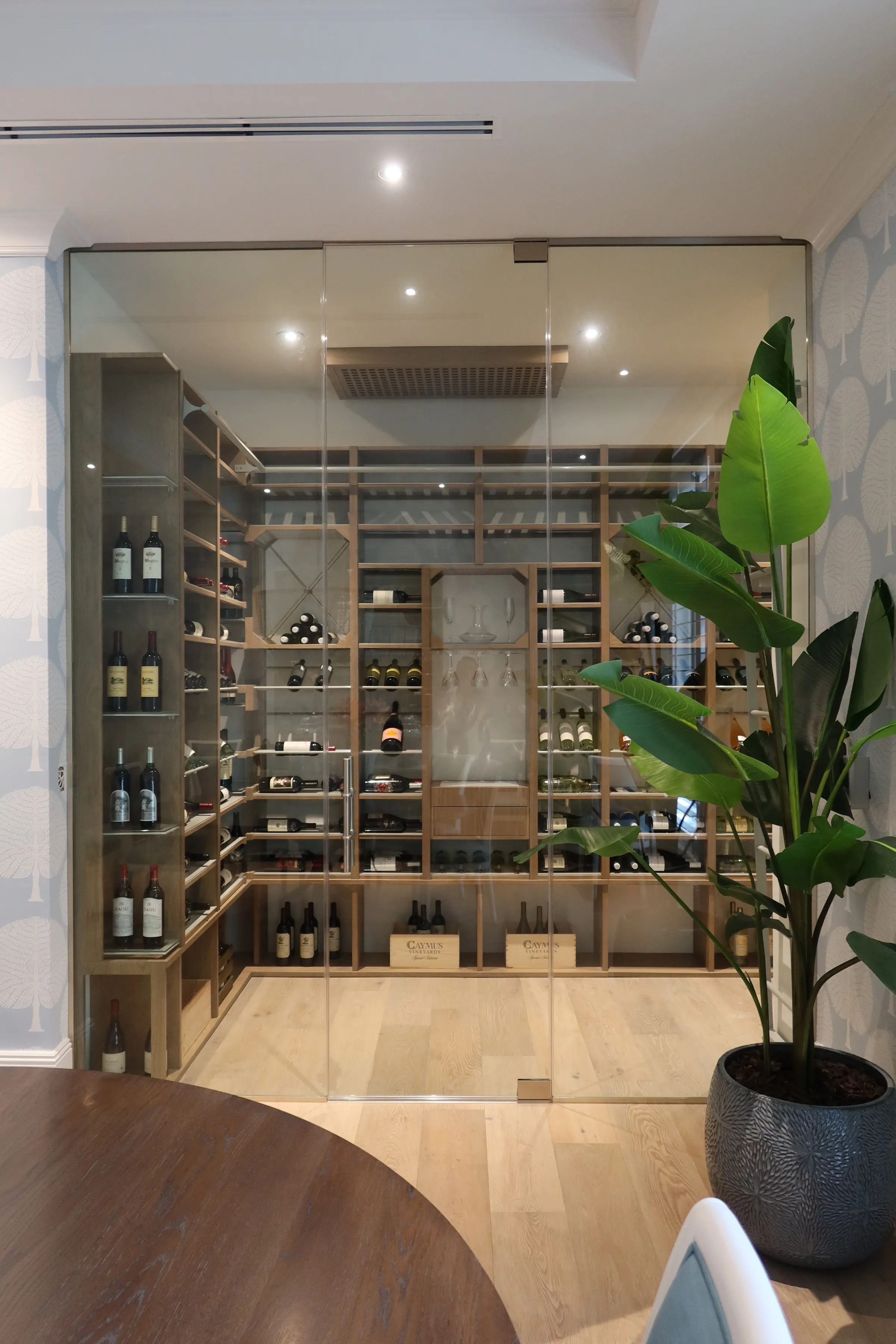 Luxury glass wine cellar Miami featuring custom metal and wooden wine racks, LED lighting, and floor-to-ceiling wine storage — photograph 1 of 4