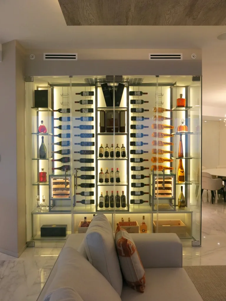 Custom wine wall Miami featuring glass enclosure, illuminated bottle displays, and contemporary, metal and wood, luxury wine storage — photograph 1 of 3
