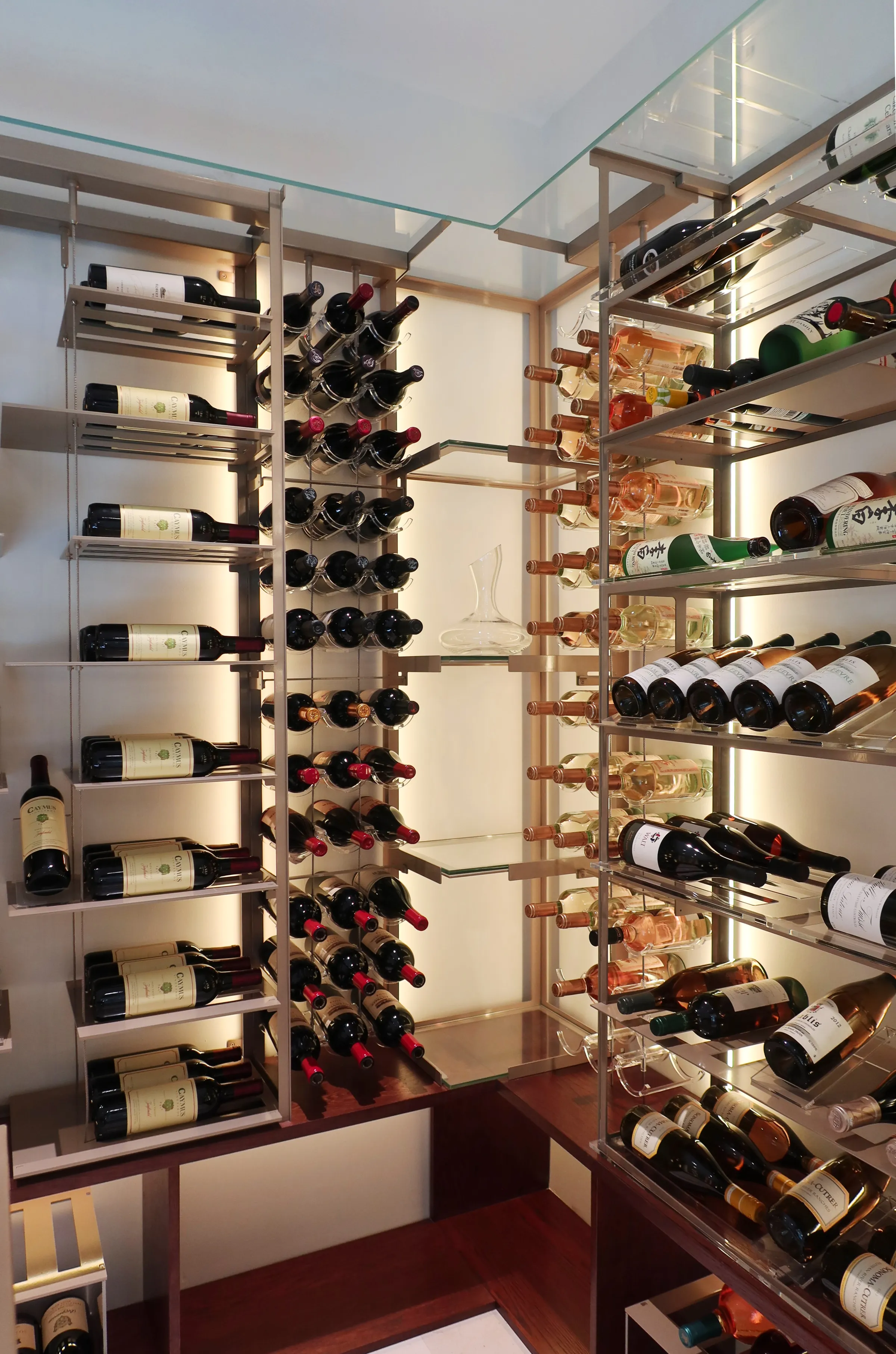 Luxury wine cellar Miami featuring custom floor-to-ceiling metal and wooden wine racks, LED lighting, and tasting table — photograph 1 of 4